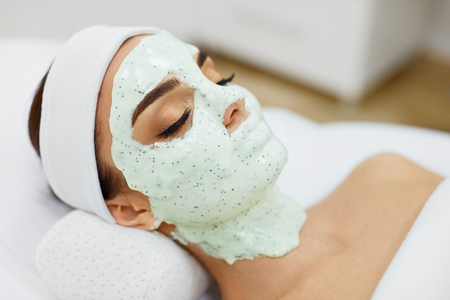 Woman Skin Care. Closeup Of Beautiful Girl With Cosmetic Mask On Facial Skin In Beauty Salon. Young Female With Face Covered With Green Moisturizing Alginate Mask. Beauty Treatment. High Resolution