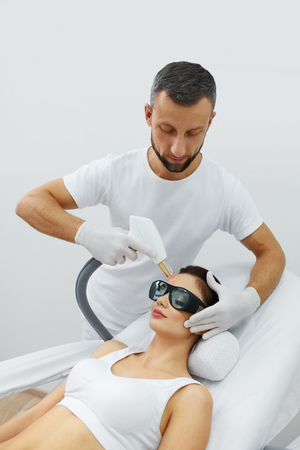 Beauty Procedure. Closeup Of Beautician Using Laser Therapy For Facial Skin Rejuvenation. Beautiful Healthy Woman Face Getting Skin Resurfacing In Spa Salon. Body Treatment. High Resolutionの写真素材