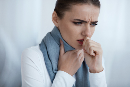Cold And Flu. Portrait Of Beautiful Young Female With Cough And Sore Throat Feeling Sick Indoors. Closeup Of Ill Unhealthy Woman In Scarf Coughing, Caught Cold. Health Care Concept. High Resolutionの写真素材