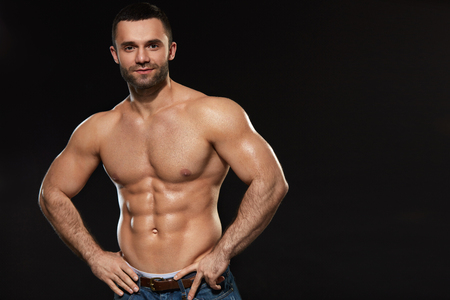 Bodybuilding. Portrait Of Muscular Sexy Young Man With Healthy Skin And Athletic Hot Body. Closeup Of Naked Strong Male With Muscular Abs On Black Background. Fitness Concept. High Resolutionの写真素材