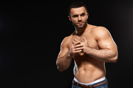Muscular Male Body. Closeup Of Handsome Healthy Young Man With Perfect Trained Naked Torso. Portrait Of Sexy Male With Fit Abs And Biceps On Black Background. Bodybuilding Concept. High Resolutionの写真素材