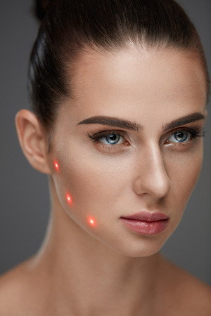 Beauty Treatment. Portrait Of Beautiful Young Woman With Soft Skin And Red Laser Points On Face. Closeup Of Sexy Healthy Woman Before Plastic Surgery On Grey Background. Cosmetology. High Resolutionの写真素材