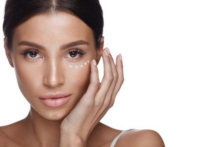 Beauty Woman Face With Makeup. Portrait Of Beautiful Female Touching Soft Smooth Facial Skin With Hands. Closeup Of Sexy Girl With Fresh Make-up And Concealer, Corrector Under Eyes. High Resolutionの写真素材