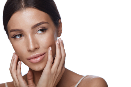 Skin Care. Closeup Of Sexy Young Woman With Clean Pure Facial Skin On White Background. Portrait Beautiful Healthy Female With Fresh Professional Makeup Touching Face. Beauty Concept. High Resolutionの写真素材