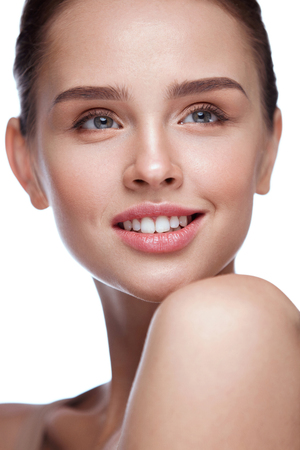 Beauty Face. Beautiful Smiling Girl With Perfect Facial Skin And Professional Makeup. Closeup Of Attractive Young Female Model With Glamourous Make-up On White Background. Cosmetics. High Resolutionの写真素材