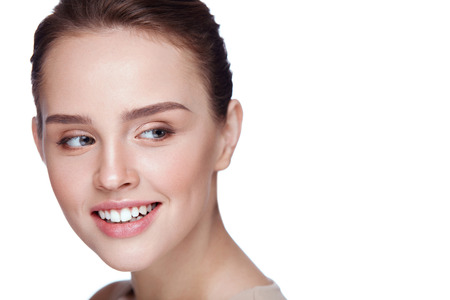 Beauty Face. Beautiful Smiling Girl With Perfect Facial Skin And Professional Makeup. Closeup Of Attractive Young Female Model With Glamourous Make-up On White Background. Cosmetics. High Resolutionの写真素材