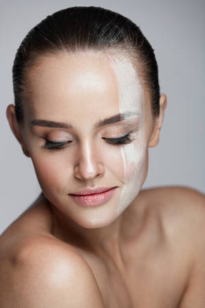 Facial Cosmetics. Closeup Of Foundation Stripe On Young Woman Beautiful Face. Portrait Of Attractive Sexy Woman With Natural Fresh Makeup And Pure Clean Smooth Skin. Beauty Conceptの写真素材