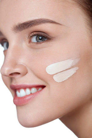 Facial Makeup. Closeup Of Skin Tone Cream Lines On Beautiful Sexy Young Woman Face. Attractive Healthy Female Model With Pure Soft Skin And Fresh Professional Make-Up. Cosmetics. High Resolutionの写真素材