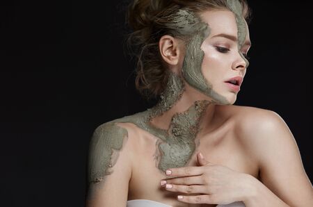 Spa Procedure. Closeup Of Beautiful Young Female Model Applying Cosmetic Mud Facial And Body Mask. Portrait Of Attractive Woman With Makeup And Clay Mask On Her Skin. Beauty Concept. High Resolutionの写真素材