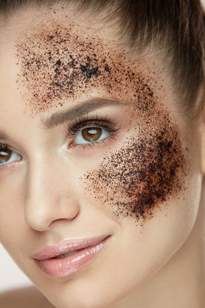 Woman Beauty Face. Closeup Of Beautiful Young Female Model With Fresh Coffee Mask, Face Scrub On Skin. Sexy Healthy Girl With Natural Makeup Exfoliating Skin With Skin Care Cosmetics. High Resolutionの写真素材