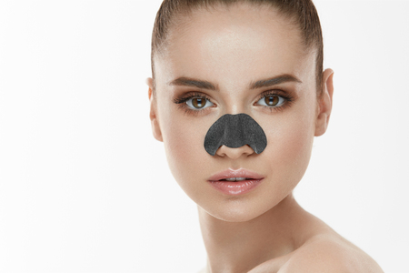 Cosmetology. Portrait Of Beautiful Female Model With Black Mask On Nose. Closeup Of Healthy Young Woman With Pure Soft Skin And Fresh Natural Makeup. Beauty And Skin Care Treatment. High Resolutionの写真素材