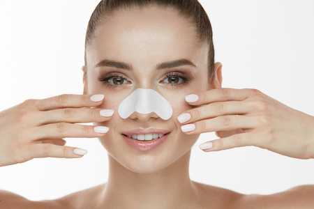 Skin Care. Closeup Of Beautiful Woman Beauty Face With White Patch, Pore Strip On Nose. Portrait Of Sexy Girl With Fresh Makeup Touching Clean Soft Pure Facial Skin With Hand. High Resolutionの写真素材