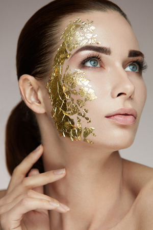 Spa Procedure. Portrait Of Sexy Girl With Gold Mask On Facial Skin Caressing Body. Closeup Of Attractive Woman With Smooth Skin And Cosmetic Product On Face. Beauty Concept. High Resolutionの写真素材
