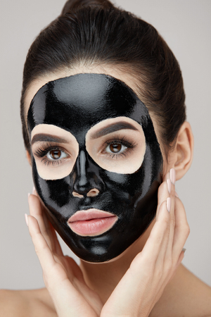Woman Beauty Face Skin Care. Closeup Of Attractive Girl Applying Black Smooth Peeling Mask On Facial Skin. Portrait Of Beautiful Female With Natural Makeup And  Cosmetic Peel Off Mask. High Resolutionの写真素材