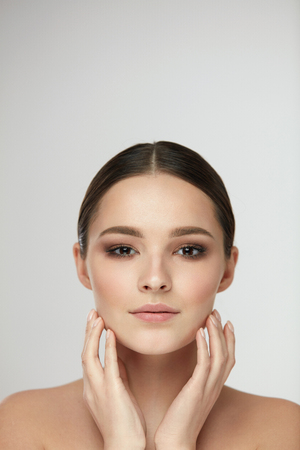 Woman Beauty Face Portrait. Closeup Of Attractive Young Female Model With Natural Makeup Touching Face. Portrait Of Beautiful Sexy Girl With Fresh Clean Soft Skin And Glamour Make-up. High Resolutionの写真素材