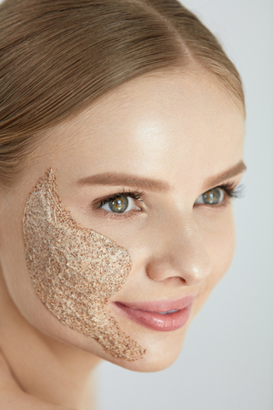 Face Skin Scrub. Portrait Of Beautiful Happy Smiling Young Woman Applying Cosmetic Peeling Mask On Facial Skin. High Resolutionの写真素材