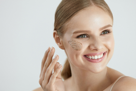 Face Skin Scrub. Portrait Of Beautiful Smiling Female Applying Cosmetic Mask, Face Scrub On Facial Skin. High Resolutionの写真素材