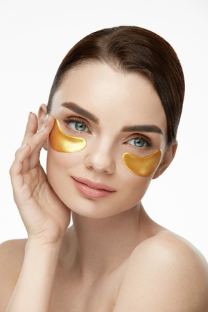 Patch Under Eyes. Beautiful Woman Face With Gold Hydrogel Patches, Lifting Anti-Wrinkle Collagen Mask On Fresh Healthy Facial Skin. High Resolutionの写真素材