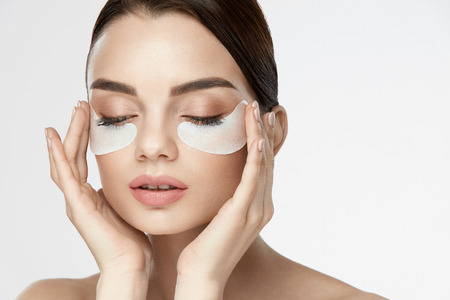 Eye Skin Mask. Portrait Of Beautiful Young Female Model With White Under Eye Skin Patches, Skin Care Product On Beauty Face. High Resolutionの写真素材