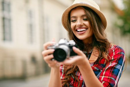 Beautiful Tourist Girl With Camera In Hands On Architecture Background. Portrait Of Happy Young...