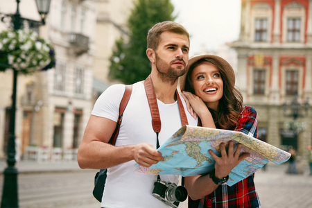 Happy Tourists. Beautiful Couple Sightseeing With Map. Smiling People In Stylish Clothes Walking With Map Around Streets Traveling To Old Town On Weekend. Travel Concept. High Quality Image.の写真素材