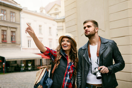 Tourist Couple Traveling And Enjoying Architecture. Portrait Of Beautiful Young Woman And Handsome Man In Love Walking Around Old Town Streets. High Resolution.の写真素材