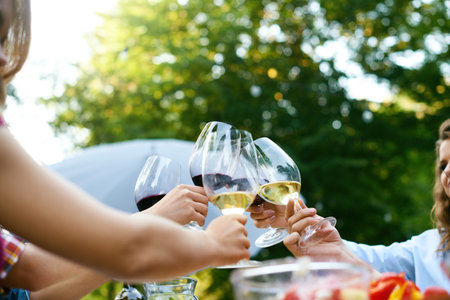 People Cheering With Drinks At Outdoor Dinner Party. Close Up Of People Hands Raising Toast With...
