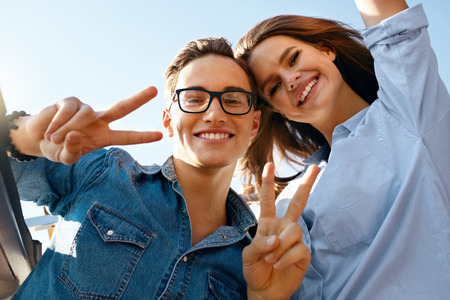 Beautiful Couple Having Fun In Summer. Happy Smiling Young Friends Enjoying Summertime. Handsome Man And Stylish Woman Traveling Together On Vacation, Posing On Blue Sky. High Quality Image.の写真素材