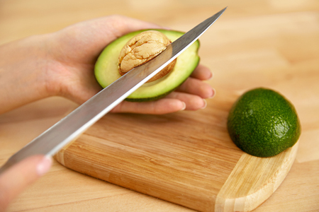 Healthy Diet. Woman Taking Out Seed From Avocadoの写真素材