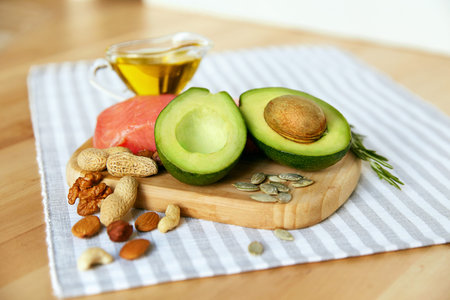 Healthy Fats. Fresh Organic Food On Table. Close Up Of Avocado, Nuts, Olive Oil And Salmon Fillet...