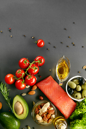 Food On Table. Healthy Food Ingredients Full Of Fats And Vitamins Such As Fresh Organic Vegetables, Nuts, Olive Oil And Salmon Fillet On Grey Background. Balanced Diet. High Resolutionの写真素材