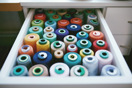 Close Up Of Colorful Sewing Threads In Drawer. Closeup Shot Of Multicolored Spools Of Thread, Sewing Accessories In Atelier.の写真素材