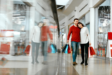 Couple Shopping. Happy Man And Beautiful Smiling Woman With Colorful Bags In Mall. High Resolution.の写真素材