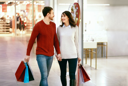Couple Shopping. Happy Man And Beautiful Smiling Woman With Colorful Bags In Mall. High Resolution.の写真素材