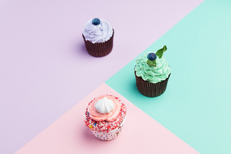 Dessert. Cupcakes On Colorful Background. Close Up Of Mini Cakes With Pastel Color Cream. High Resolutionの写真素材