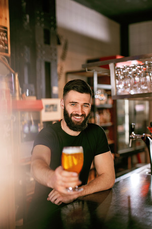 Craft Beer. Man Holding Glass With Beer In Pub, Bartender At Bar Counter. High Resolution.の写真素材