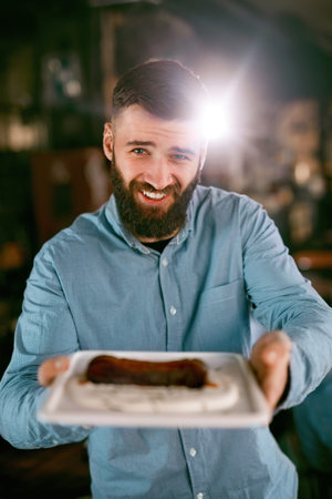 Happy Waiter Holding Plate With Tasty Food In Pub. High Resolution.の写真素材