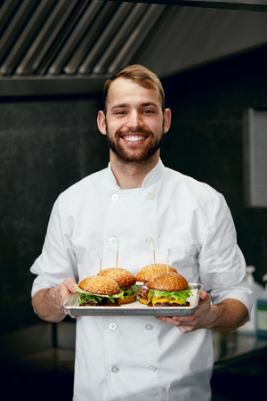 Smiling Chef With Burgers In Modern Restaurant Kitchen. High Resolution.の写真素材