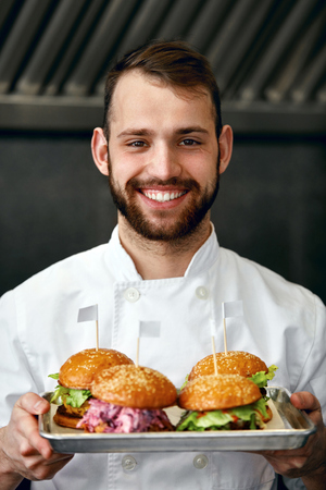 Smiling Chef With Burgers In Modern Restaurant Kitchen. High Resolution.の写真素材