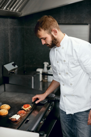 Chef Cooking Burgers In Restaurant Kitchen, Frying Meat On Grill. High Resolution.の写真素材