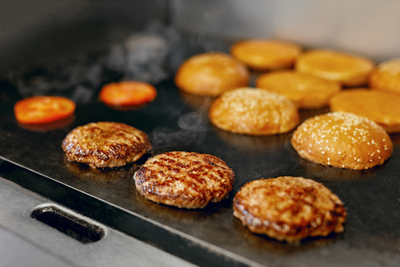 Cooking Burgers. Meat And Buns Roasting On Grill In Restaurant Kitchen. High Resolution.の写真素材