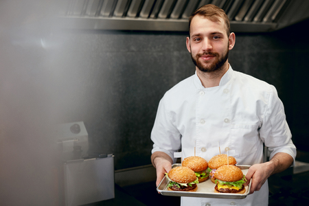 Smiling Chef With Burgers In Modern Restaurant Kitchen. High Resolution.の写真素材