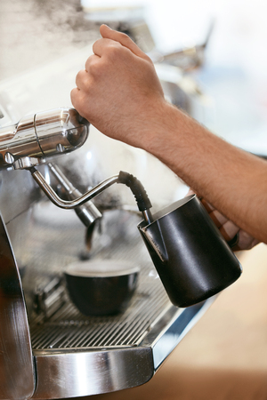 Barista Preparing Coffee On Coffee Machine Closeup, Steaming Milk In Cup In Cafe. High Resolution.の写真素材