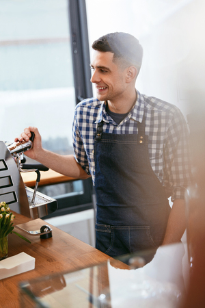 Barista At Cafe. Portrait Of Young Man Working In Coffee Shop With Coffee Machine. High Resolution.の写真素材