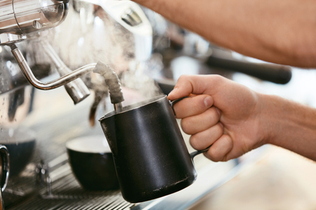 Barista Preparing Coffee On Coffee Machine Closeup, Steaming Milk In Cup In Cafe. High Resolution.の写真素材