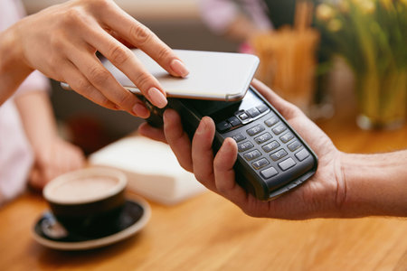 Paying With Mobile Phone In Cafe, Closeup Of Hands Pay With In Coffee Shop. High Resolution.