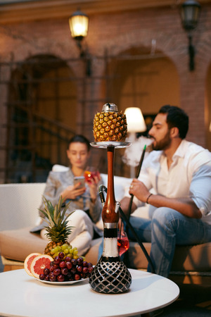 Fruit Shisha In Hookah Bar For Couple. People Smoking Hookah With Fruits, Resting In Luxury Lounge Cafe. High Resolutionの写真素材