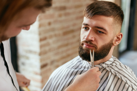 Beard Cut In Barber Shop. Barber Cutting Man's Beard With Scissors, Doing Haircut. High Resolutionの写真素材