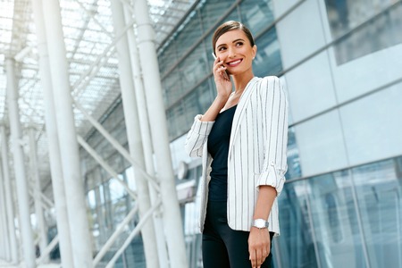 Beautiful Woman With Phone Work Near Business Officeの写真素材