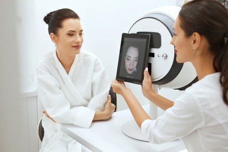 Face Skin Analyze. Cosmetologist Analyzing Woman Facial Skin At Cosmetology Clinic. High Resolutionの写真素材